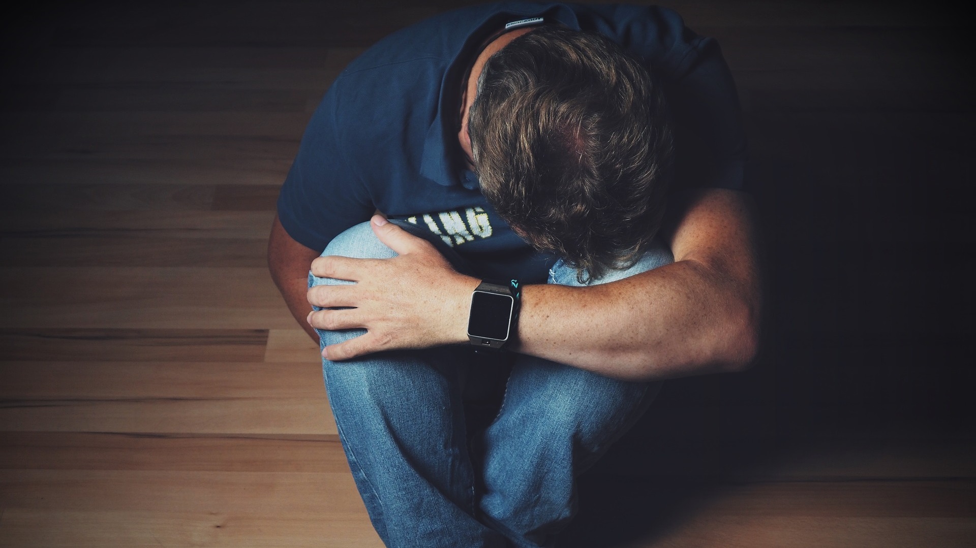 A man cradles his head on his knees. Nutrition for depression and anxiety doesn't have to be difficult with Eat for Life.