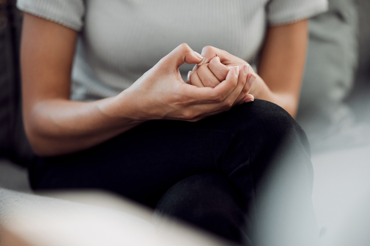 A woman is picking at her nail with her hands in her lap. If you've ever taken a Do I have OCD test, this page is for you.