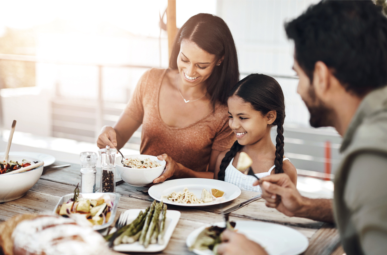 a family eats around a dinner table, their plates are almost clean. Eat for Life provides ADHD Nutrition in Pinehurst.