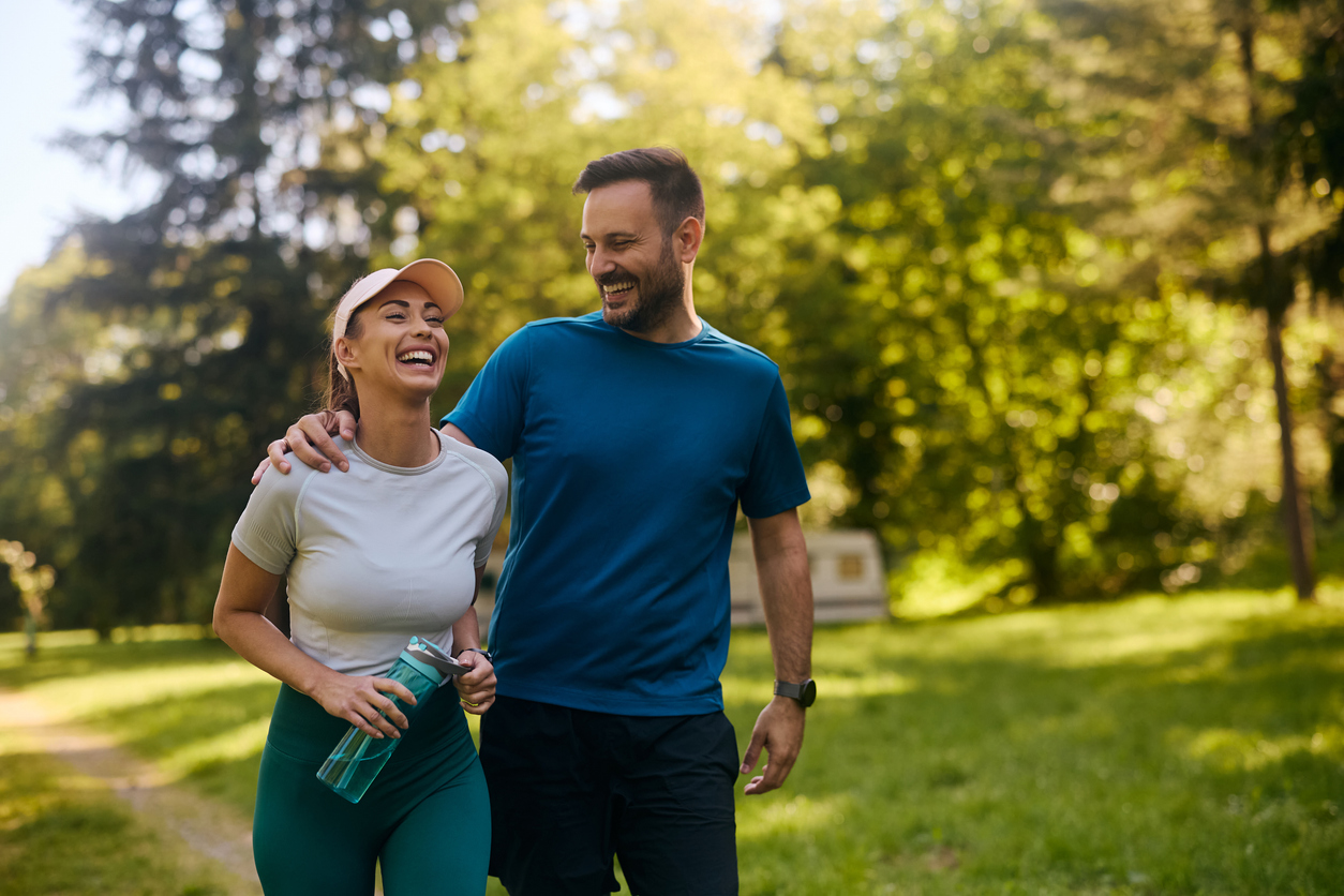 A happy couple go for a walk in the woods, they are both smiling. Eat for life is here to provide nutritional counseling for eating disorders in Durham.